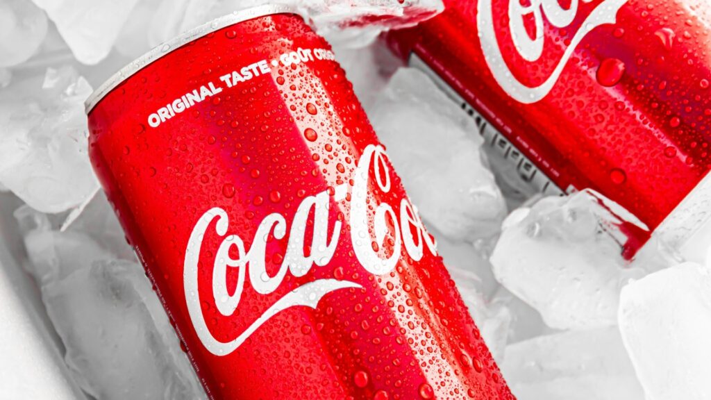 Twee koude Coca-Cola blikjes met condens in ijs, passend bij aanbod van een Coca-Cola groothandel