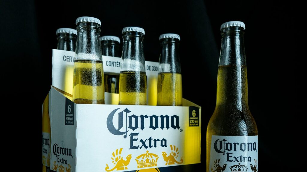 Corona groothandel levering met sixpack Corona Extra bierflesjes van 330 ml tegen donkere achtergrond